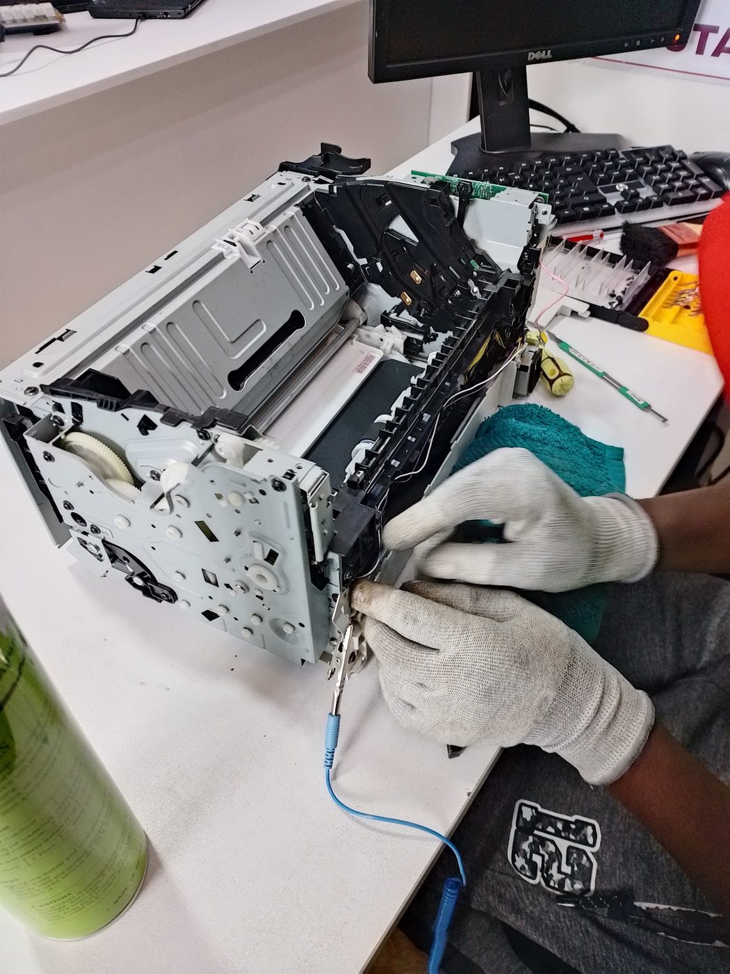 Technician repairing a printer mechanism on the workshop bench