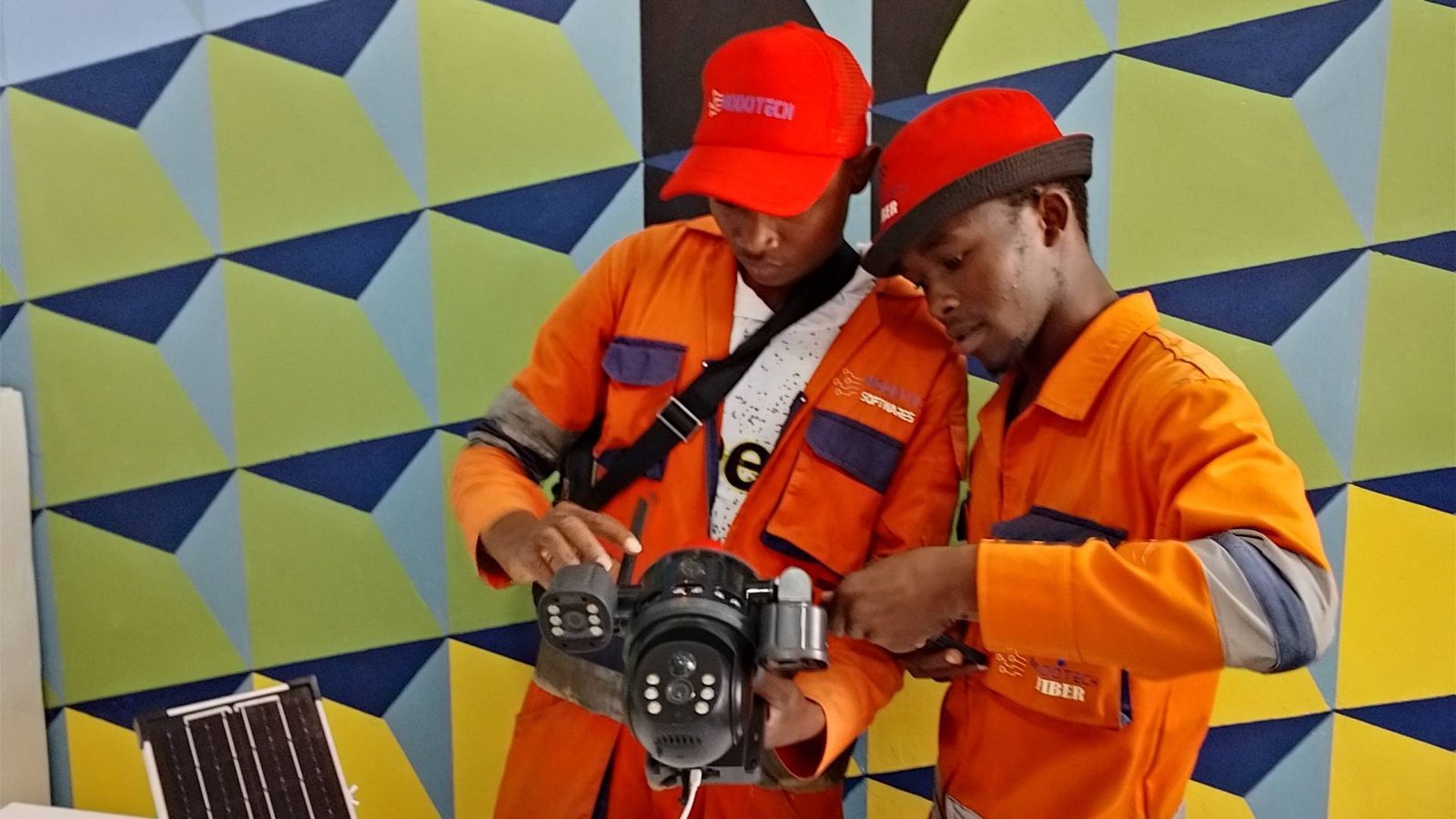 Two ModoTech technicians configuring an outdoor CCTV camera